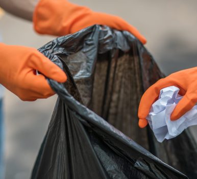 Men and women helped to collect garbage in a black bag.